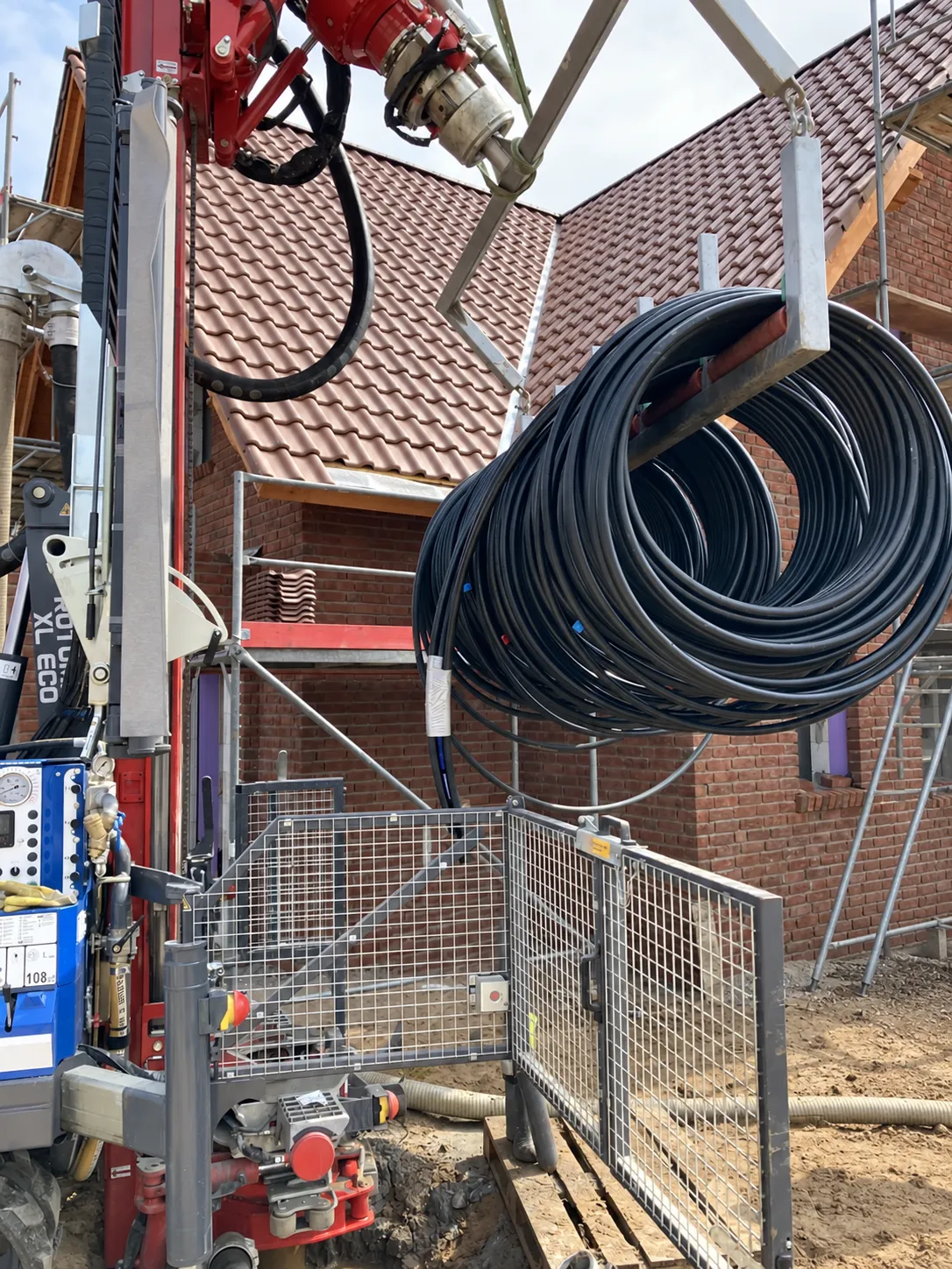 Aufgerollte Erdwärmesonde wird am Bohrgerät positioniert