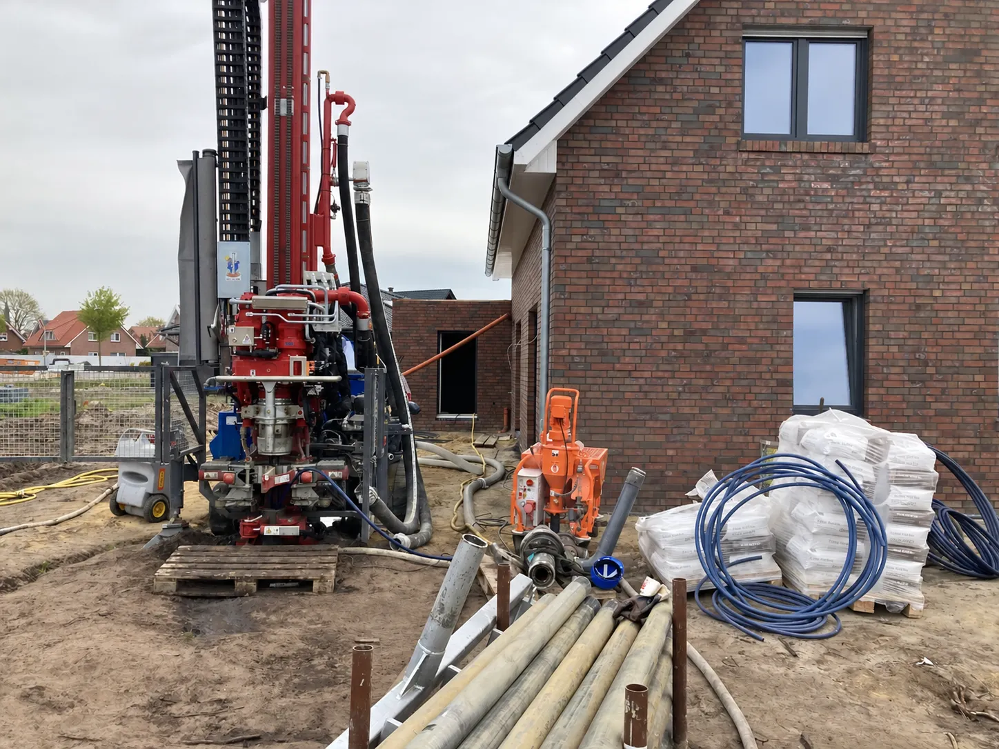 Geothermie-Bohranlage auf einer Baustelle neben einem Neubau