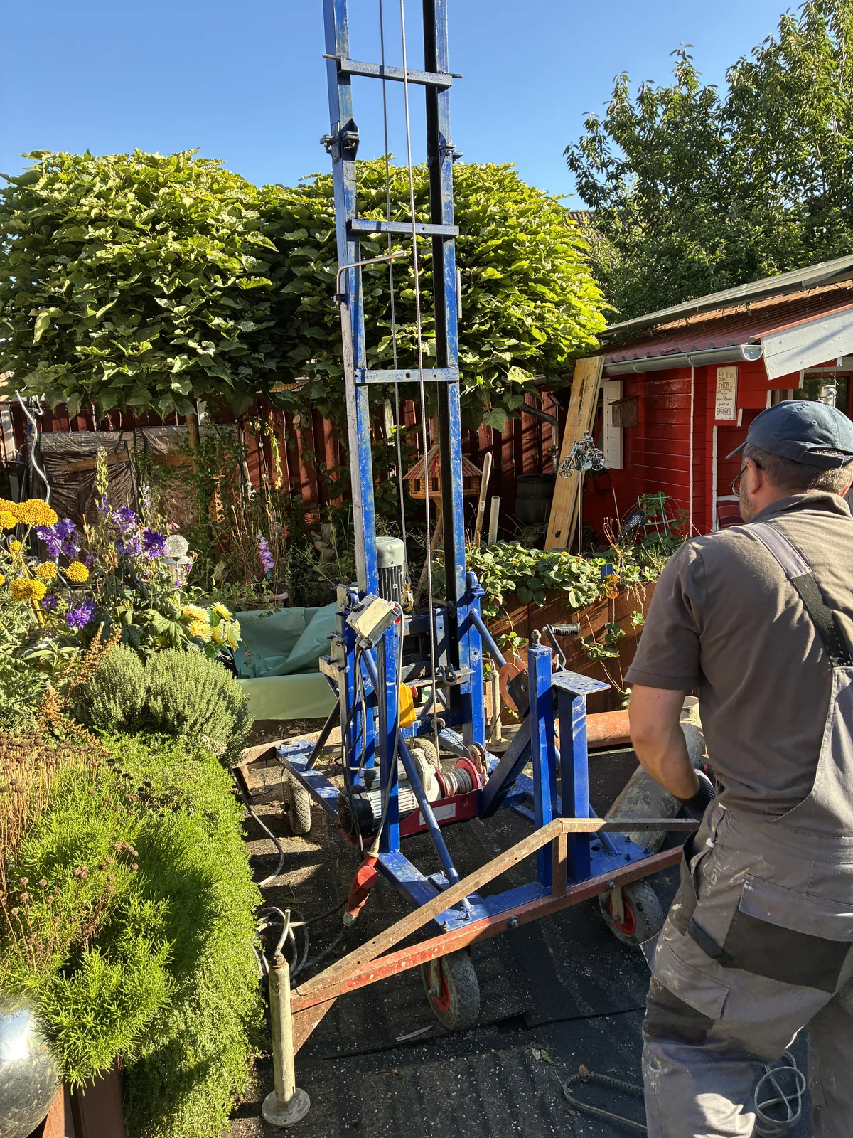 Brunnenbauer an einer mobilen Bohranlage auf engem Raum