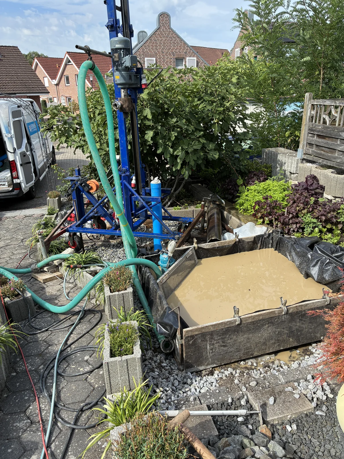Kompakte Brunnenbohranlage in einer schmalen Zufahrt an einem Wohnhaus