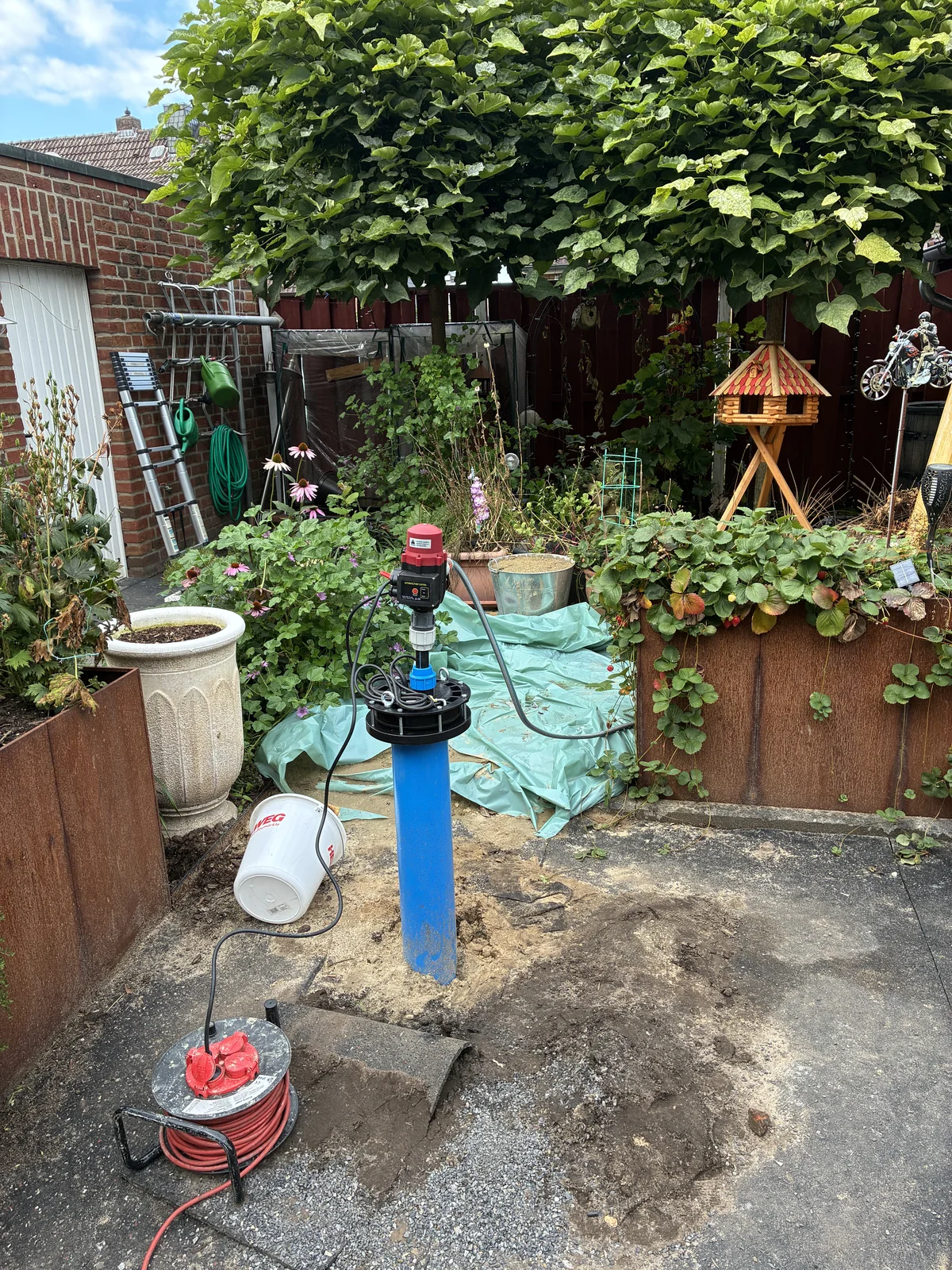 Installierte Pumpentechnik an einem Gartenbrunnen